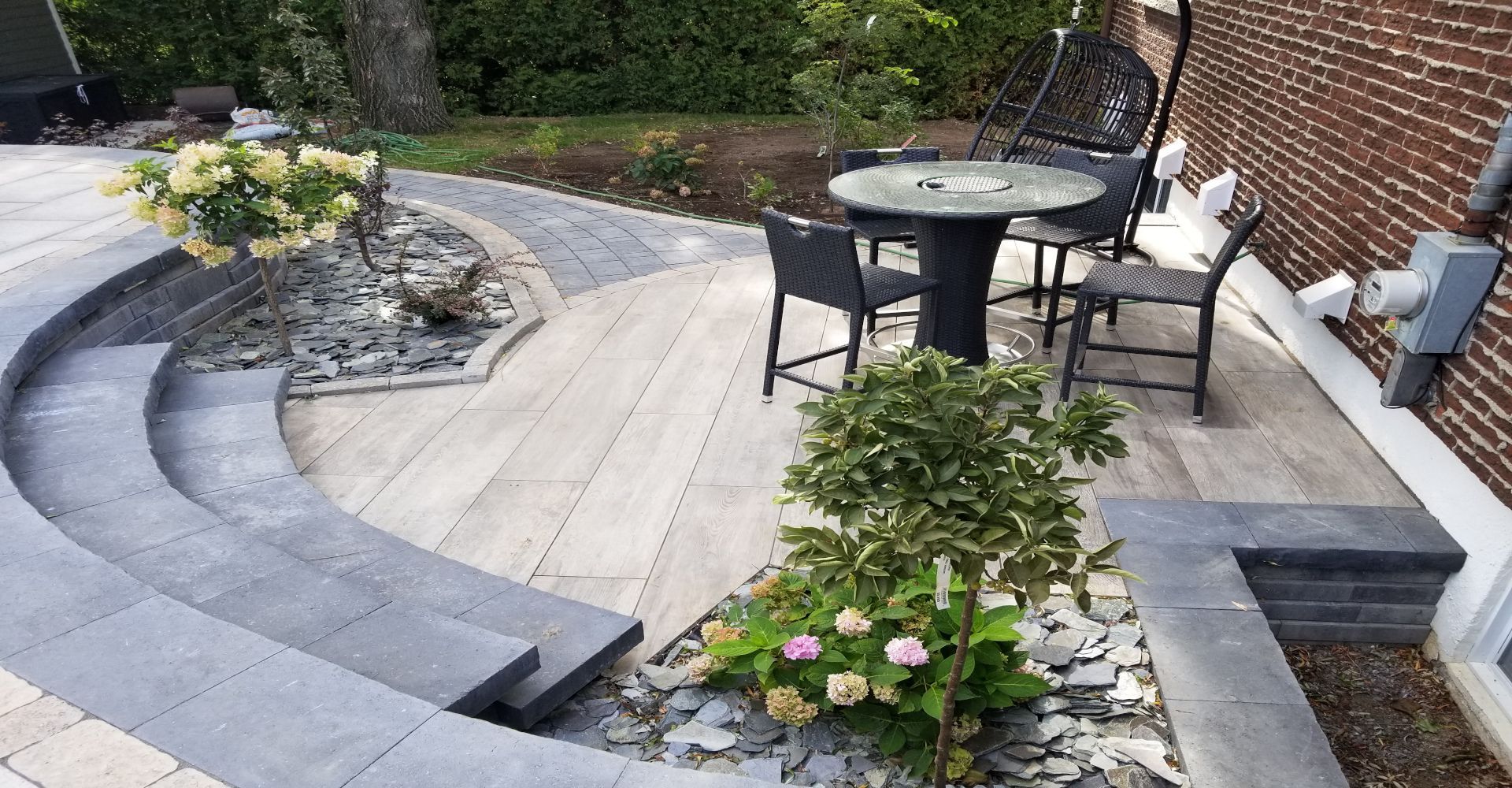 Un patio avec une table et des chaises dans l'arrière-cour d'une maison.