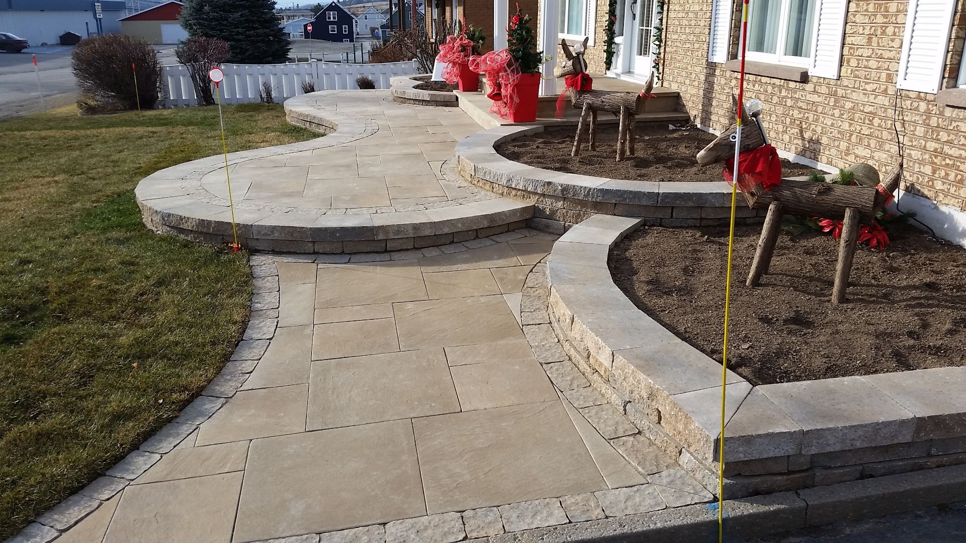 Une allée est mesurée par un ruban à mesurer devant une maison