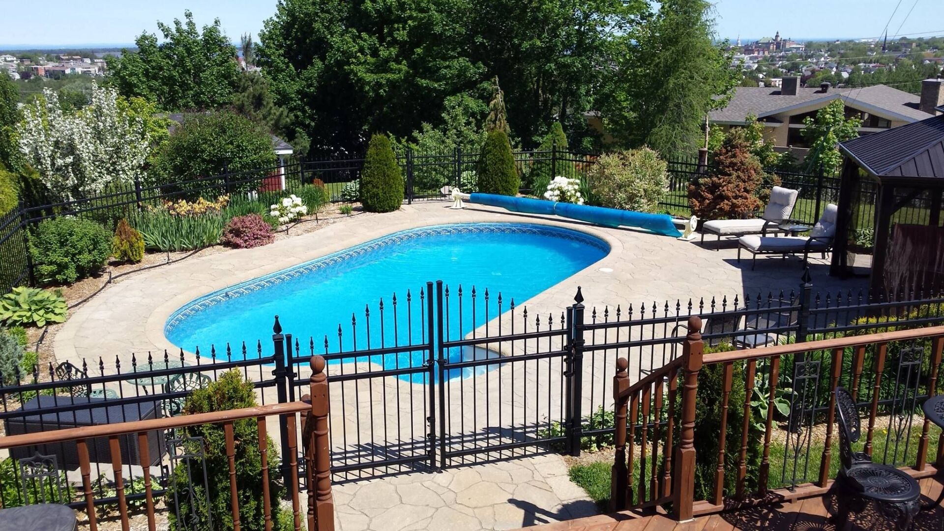 Une grande piscine est entourée d'une clôture et d'un gazebo.
