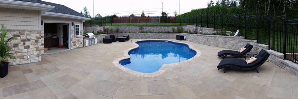 Il y a une grande piscine dans l'arrière-cour d'une maison.