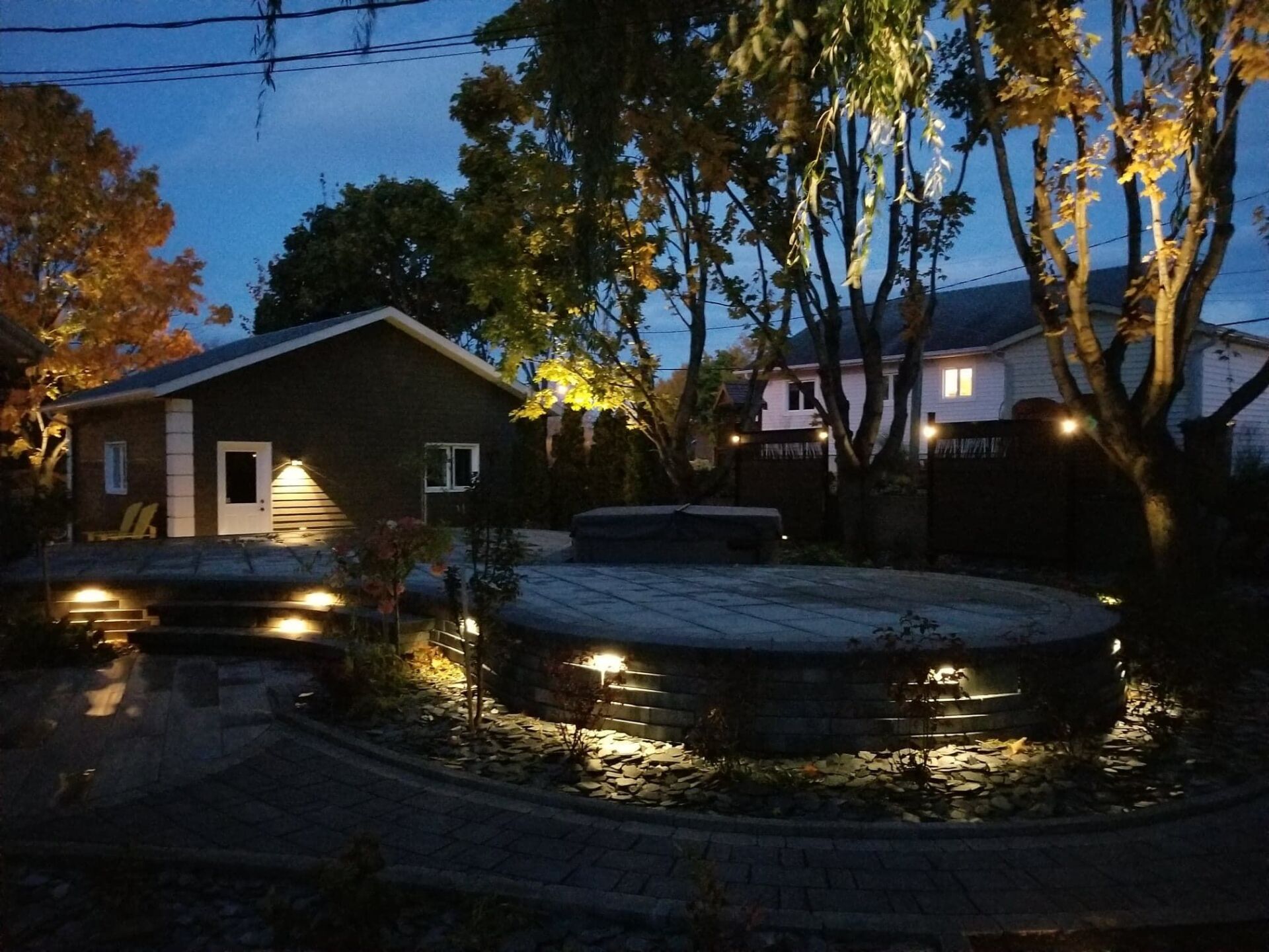 Une maison avec un jacuzzi devant elle la nuit