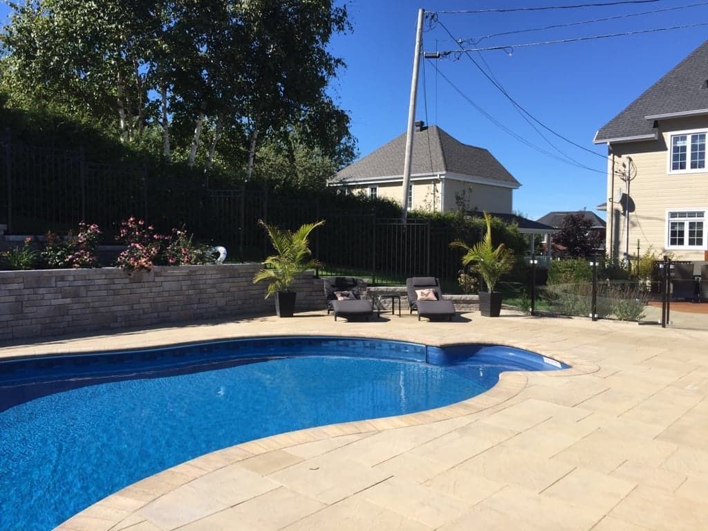 Il y a une grande piscine dans l'arrière-cour d'une maison.