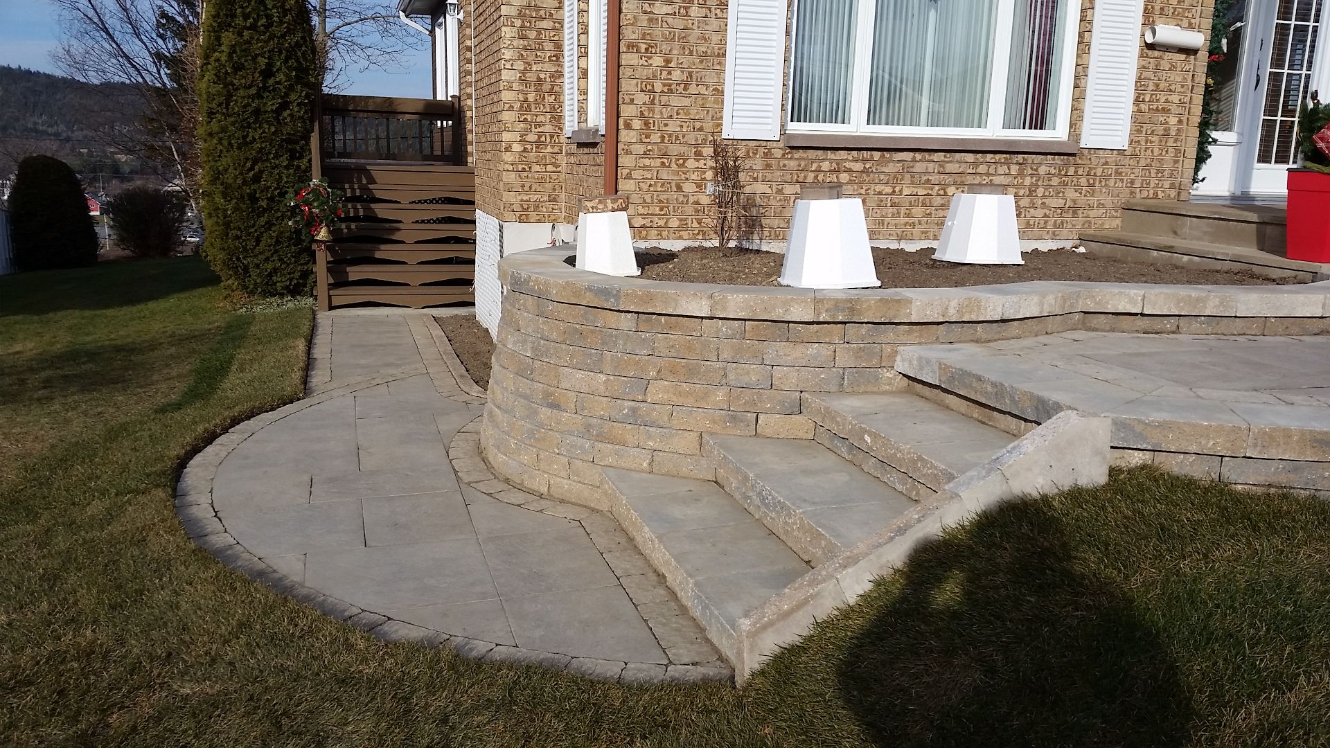 Une maison en briques avec un patio et des escaliers devant