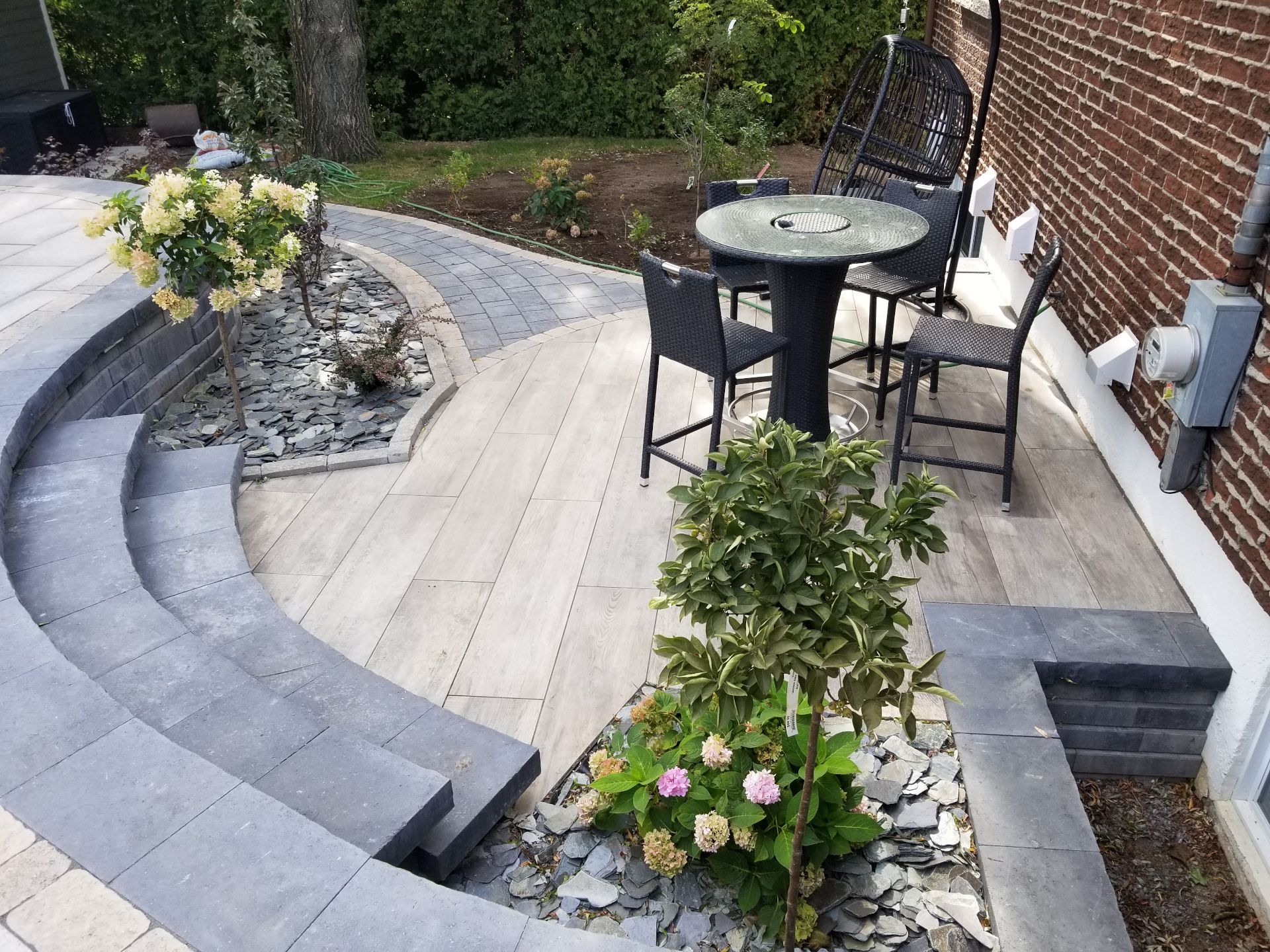 Un patio avec une table et des chaises devant un bâtiment en briques