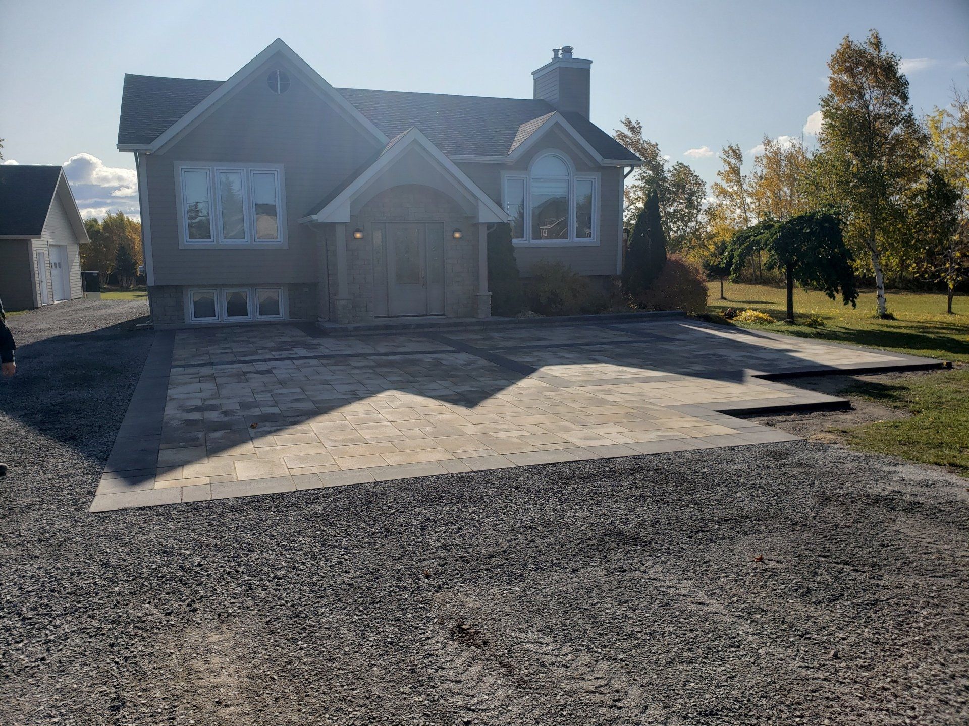 Une grande maison avec une allée de gravier devant elle