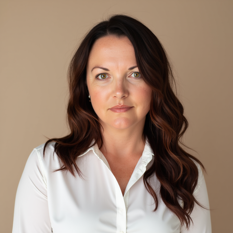 Man with glasses and red beard, wearing a suit in an office setting.