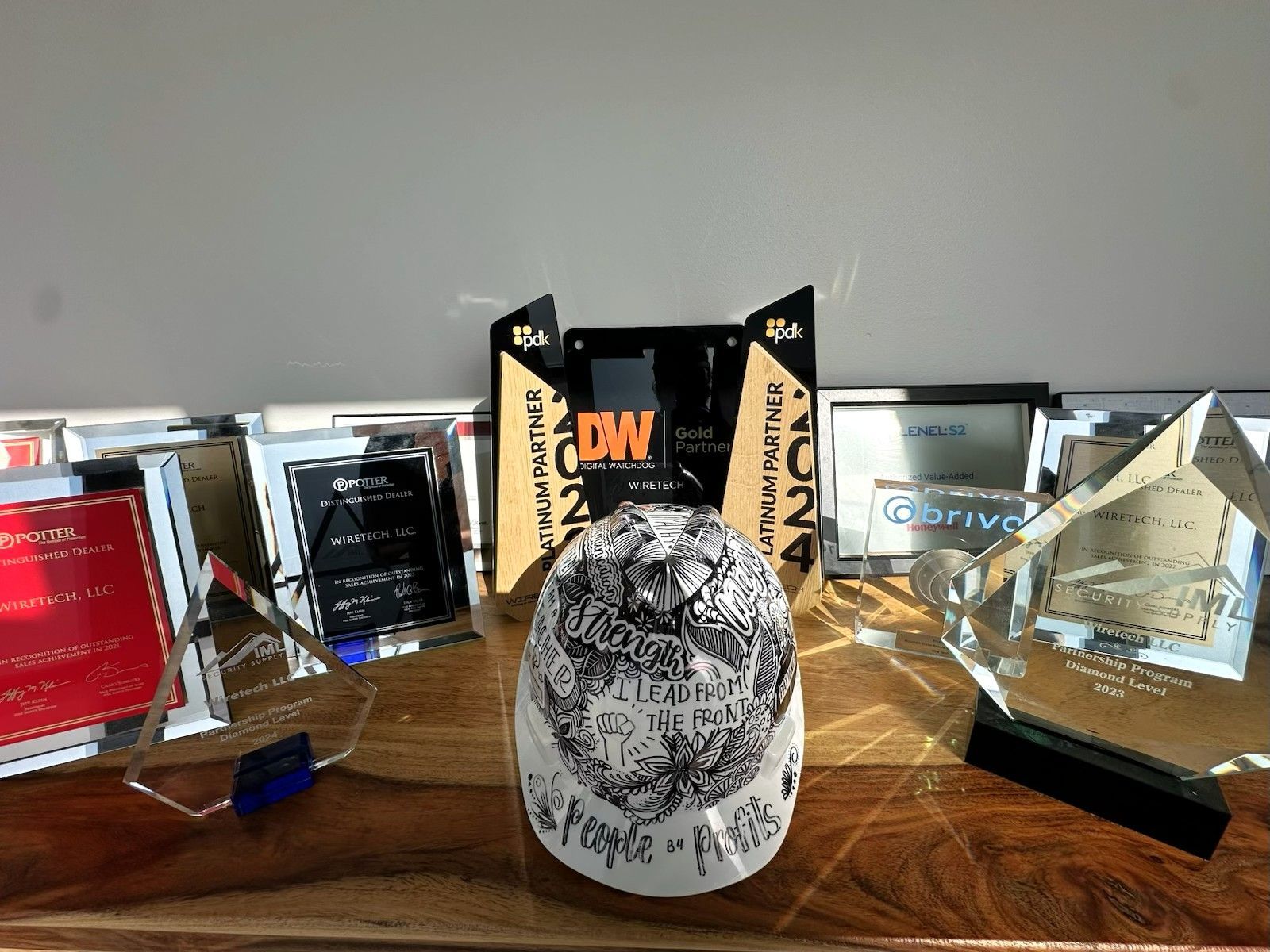 Hard hat on a wooden surface, with a blurred background of awards.
