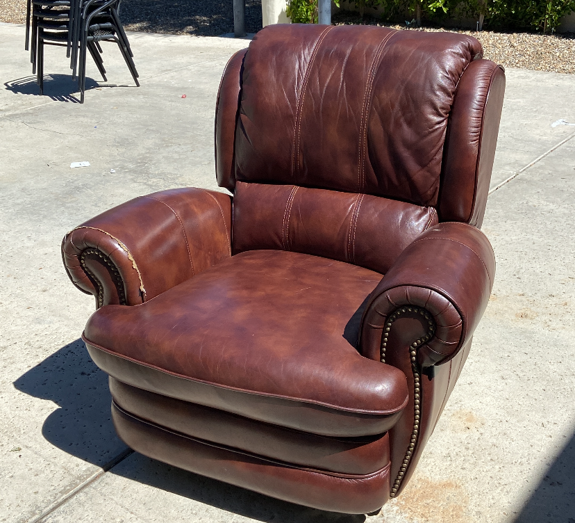 Brown leather recliner on a concrete surface. Brown leather recliner on a concrete surface.
