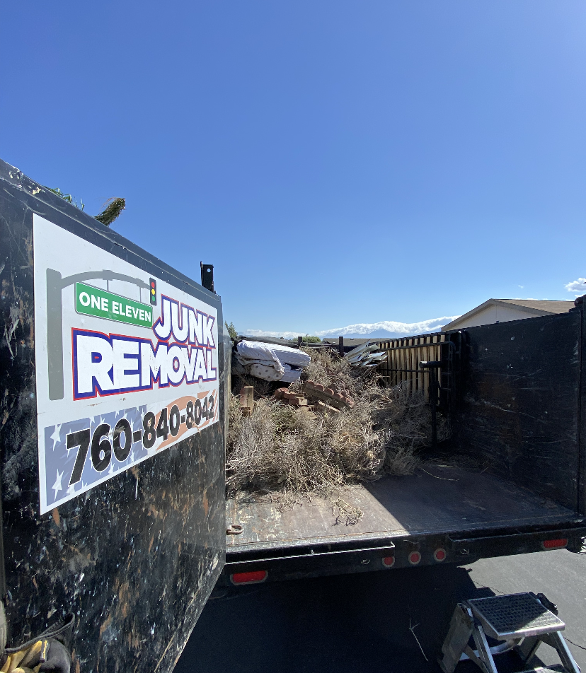 Waste collection workers emptying a yellow recycling bin into a truck. Waste collection workers emptying a yellow recycling bin into a truck.