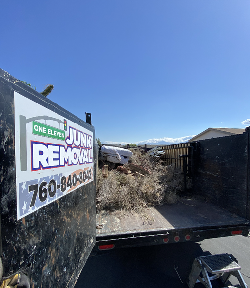 Waste collection workers emptying a yellow recycling bin into a truck. Waste collection workers emptying a yellow recycling bin into a truck.