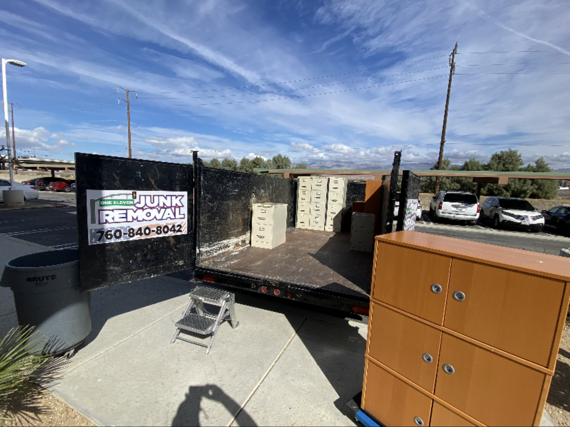 Truck bed filled with old office furniture; removal service.