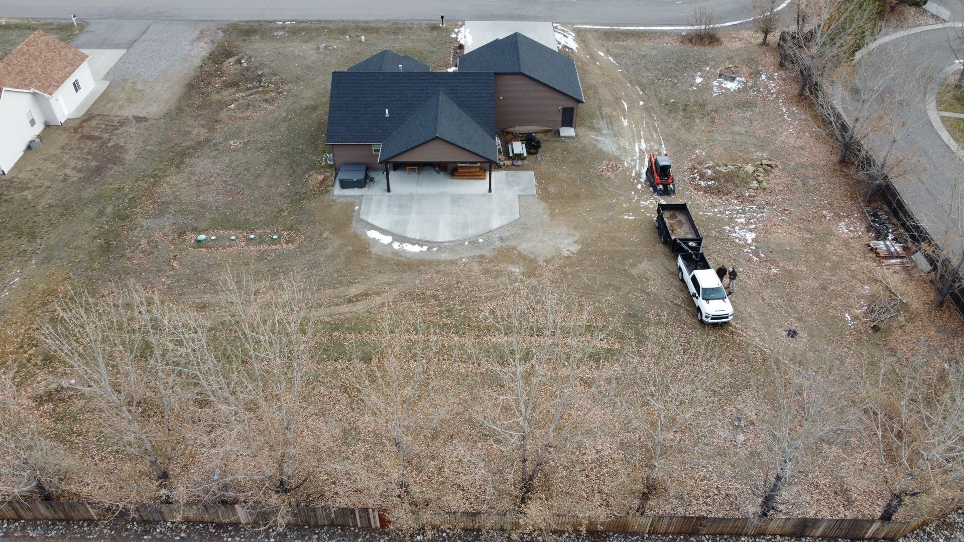 Demolition of a house. An excavator tears down a roof, debris in a dumpster. Outdoors.