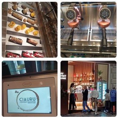 Piatto di frutti di mare con limoni e arance su un tavolo; bottiglie e bicchiere di vino sullo sfondo.