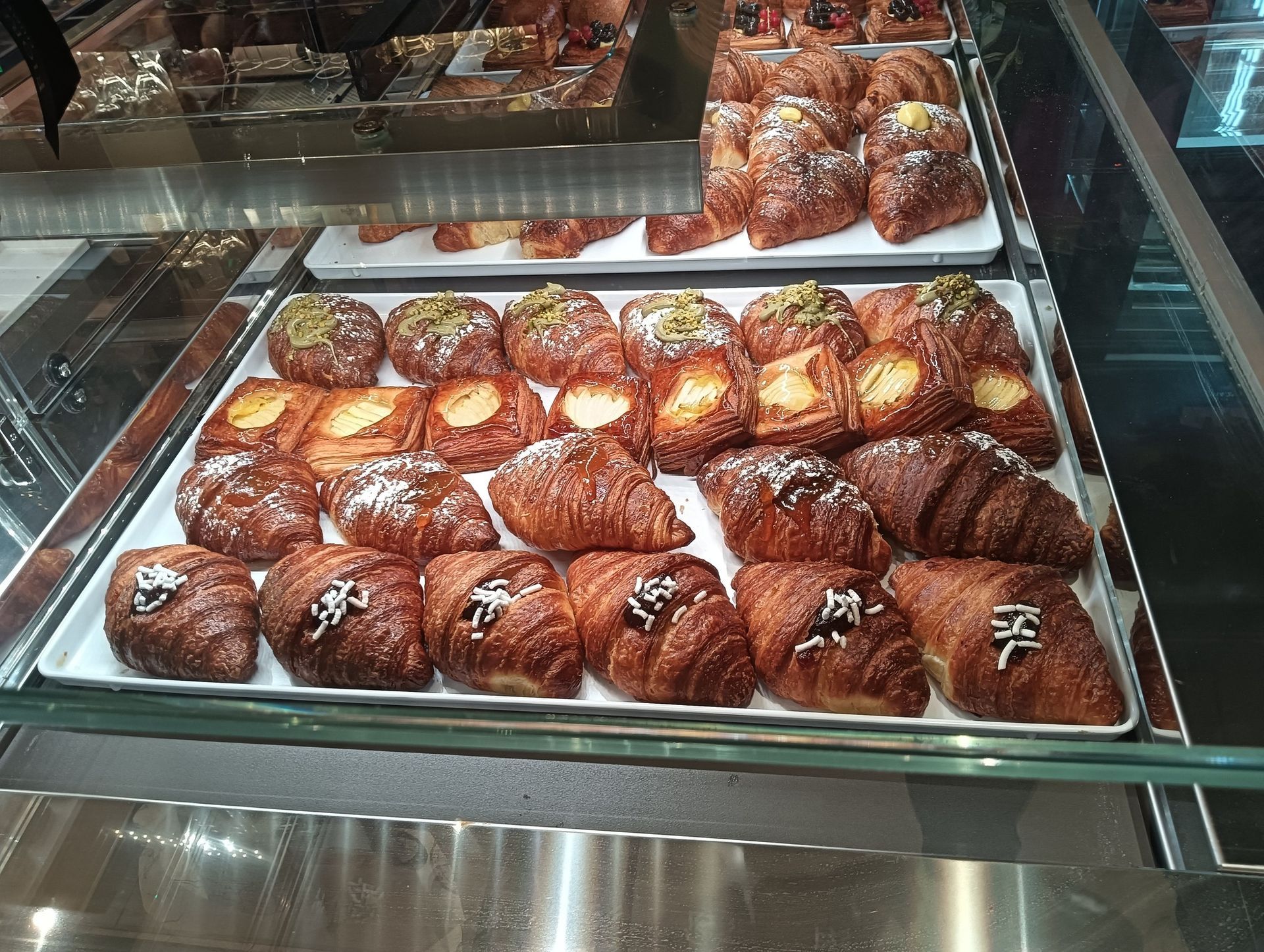 Pasta ai frutti di mare con gamberi, cozze, polpo, pomodori ed erbe aromatiche su un piatto bianco.