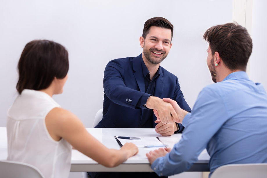 Lawyer Shakes Hands With a Client Across a Desk — Australian Employee Lawyers in Broadbeach Waters, QLD