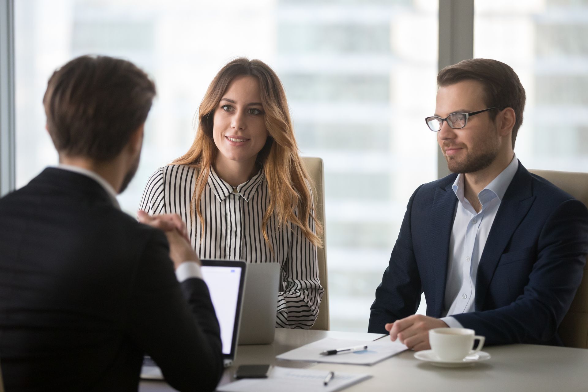Three Professionals in Business Attire Sit Around a Desk — Australian Employee Lawyers in Broadbeach Waters, QLD