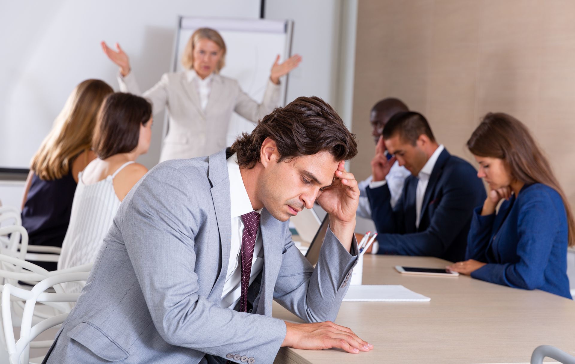 A Stressed Person Sits at a Desk During a Meeting — Australian Employee Lawyers in Broadbeach Waters, QLD