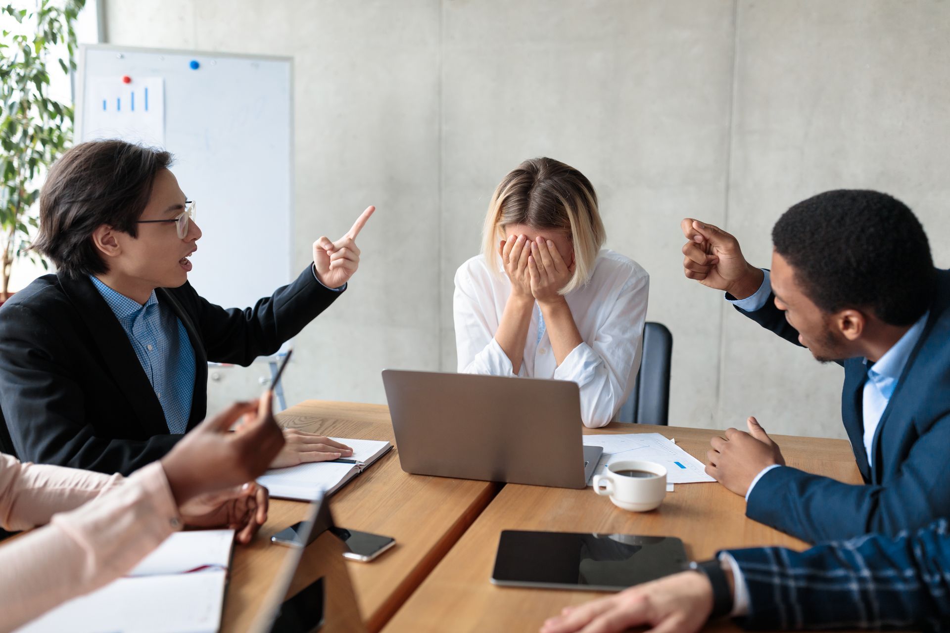 Employee Sits While Two Coworkers Point at Them in an Office Setting — Australian Employee Lawyers in Sunshine Coast, QLD