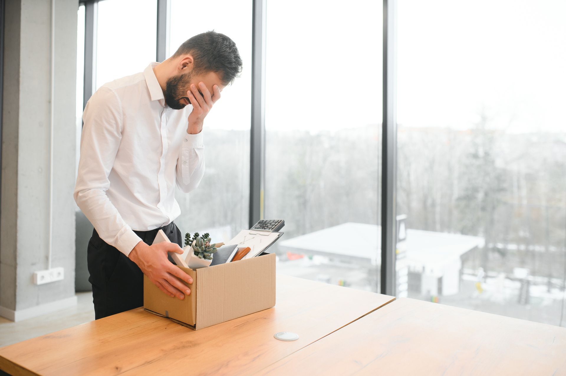 Employee Stands by a Desk, Looking Distressed — Australian Employee Lawyers in Broadbeach Waters, QLD