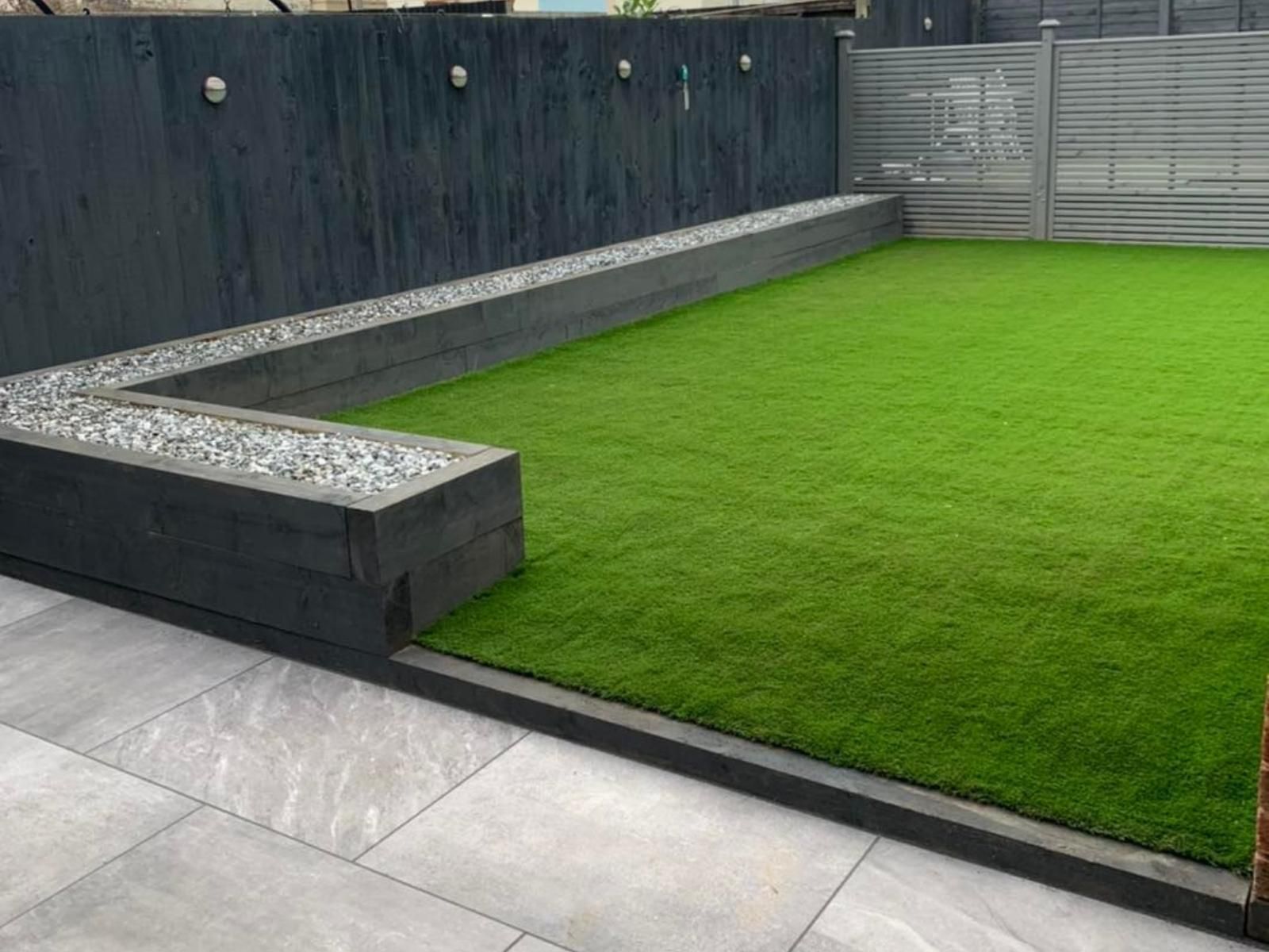 Bespoke Artificial Grass Peterborough completed artificial lawn installation including raised garden wall surrounding sections of the new fake lawn