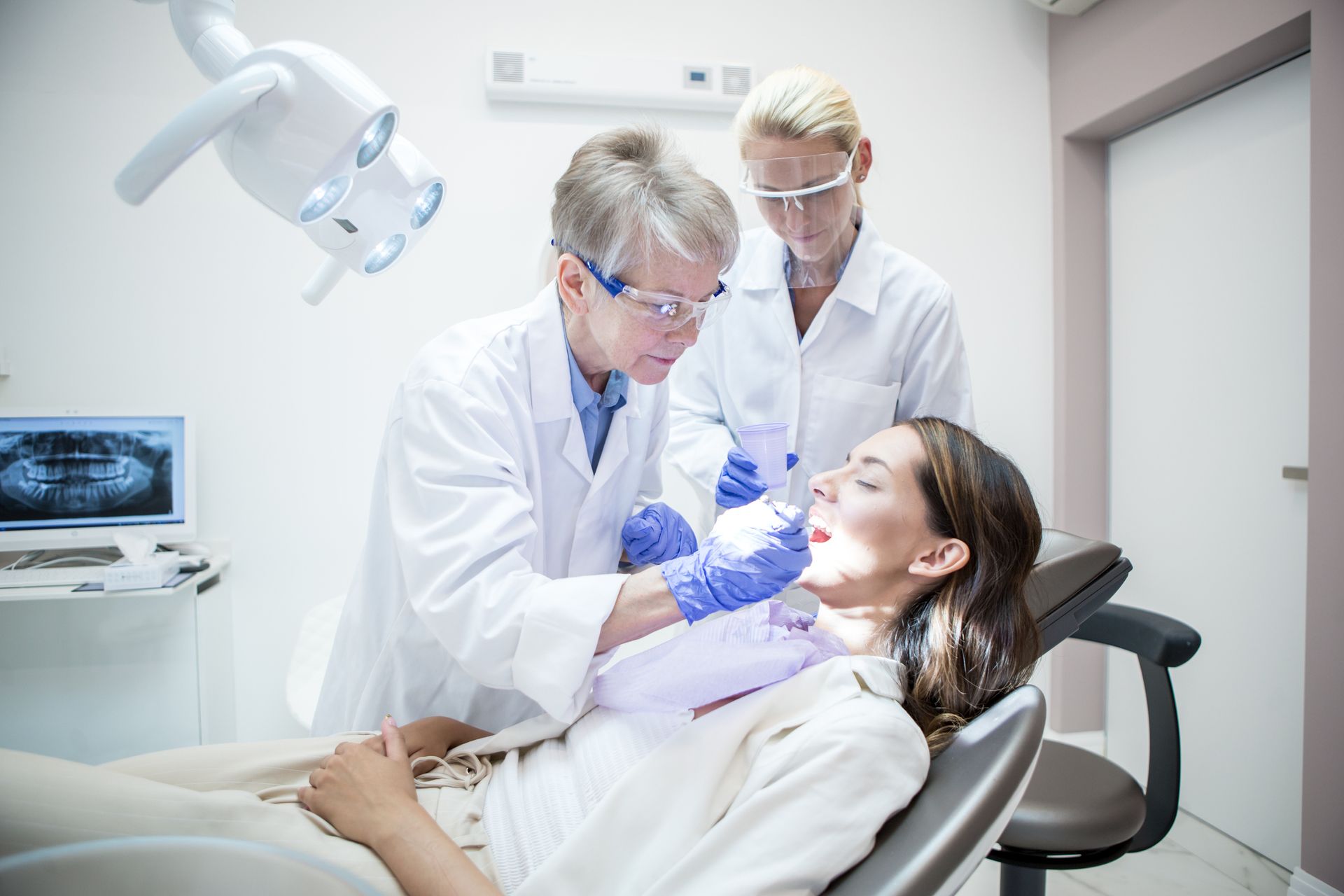 A dentist is cleaning a patient’s teeth.