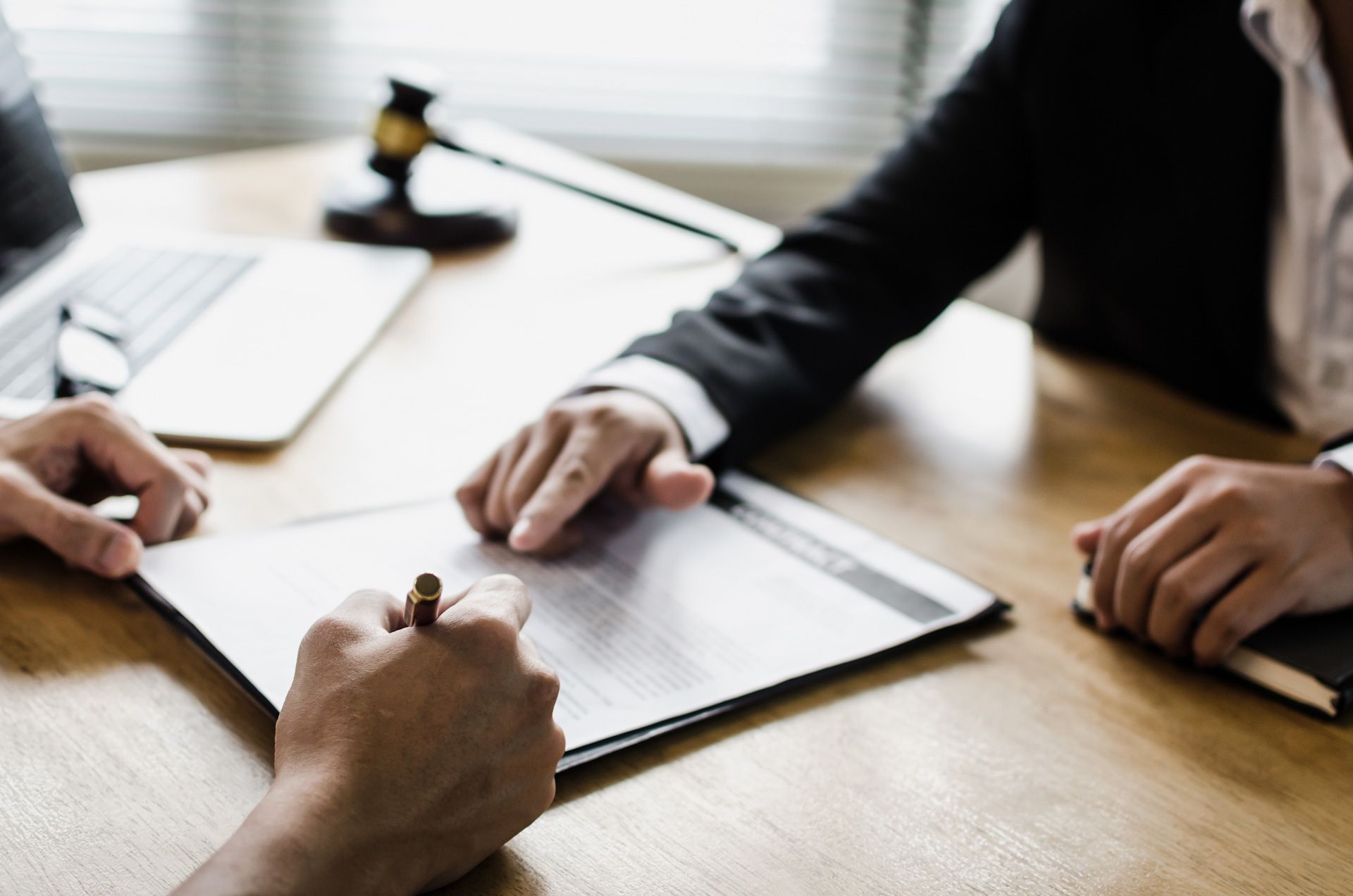 A man and a woman are sitting at a table signing a document