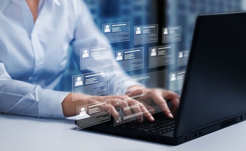 A woman is typing on a laptop computer.