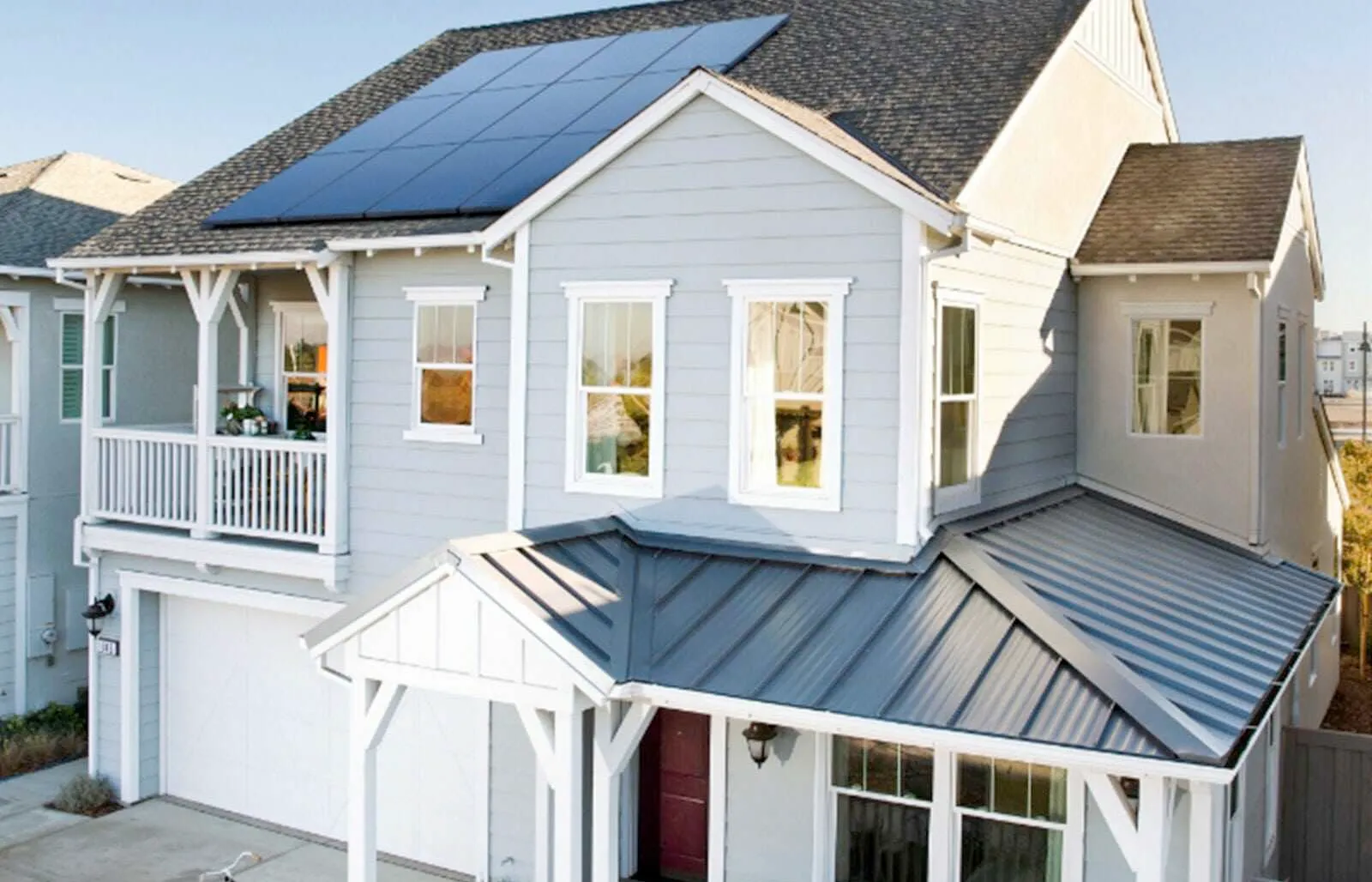A white house with solar panels on the roof