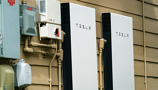 two tesla batteries are attached to the side of a house