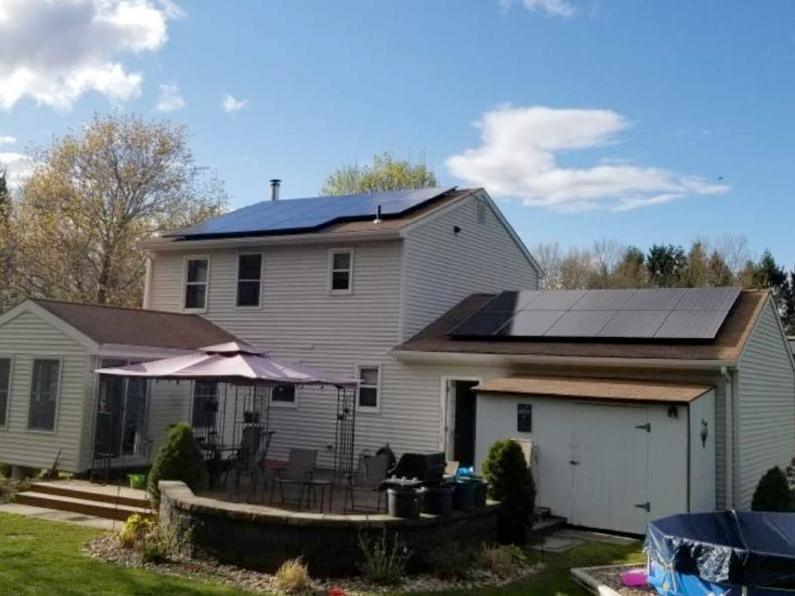 A white house with solar panels on the roof