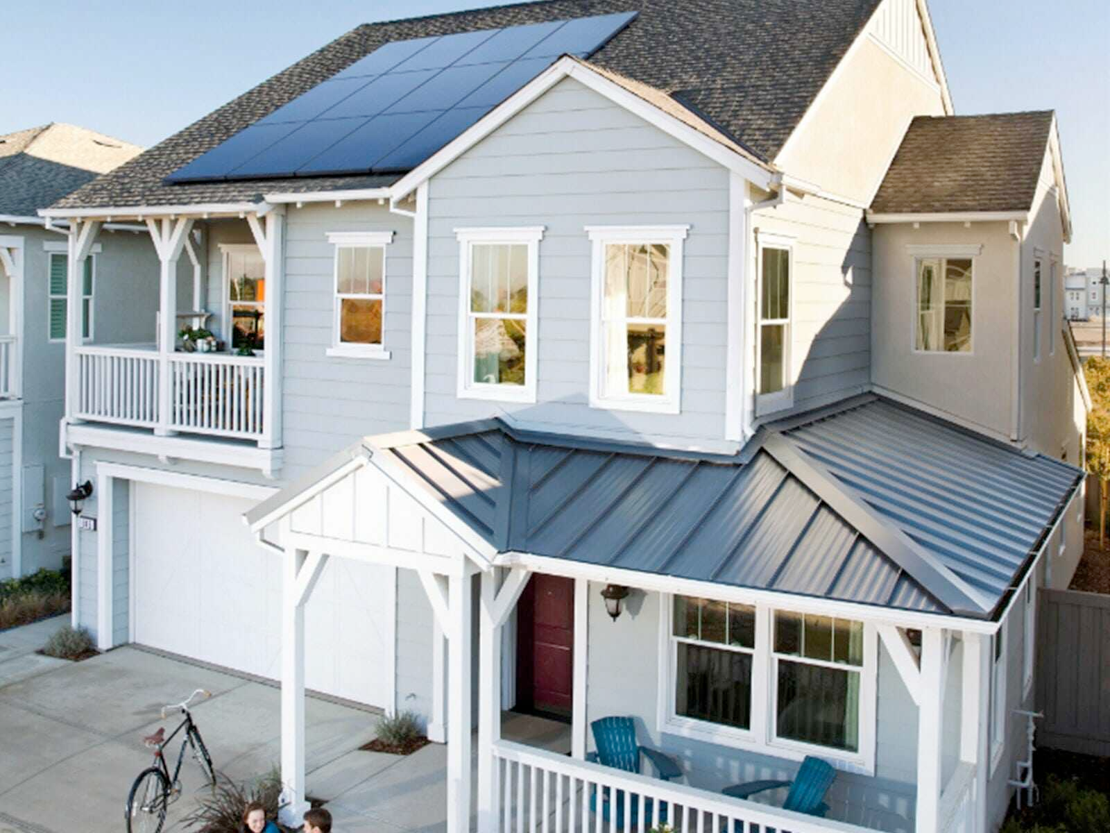 A white house with solar panels on the roof