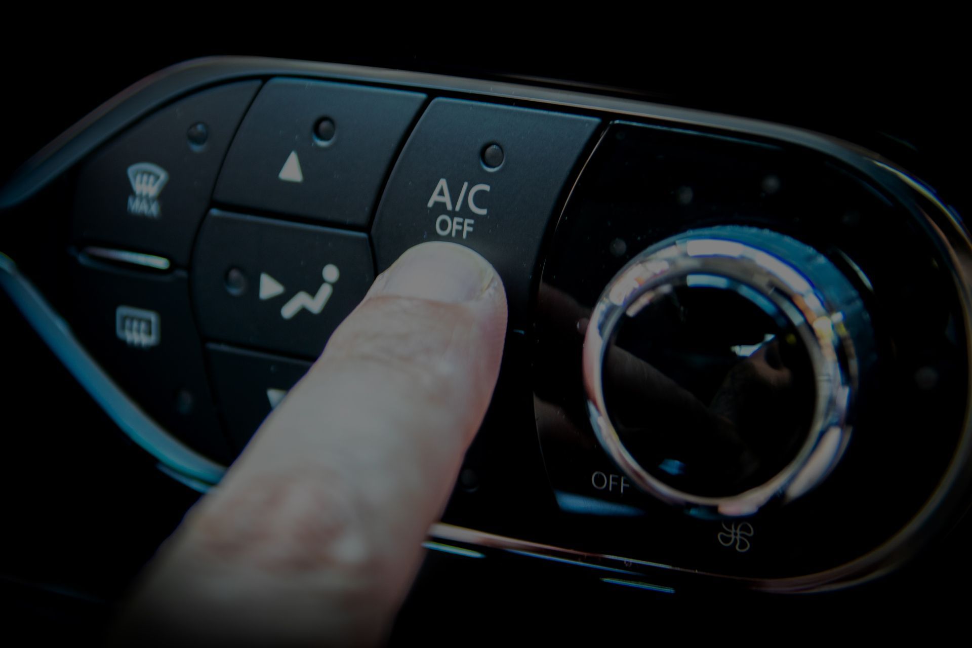 Finger pressing the A/C Off button on a car's dashboard control panel. | Importsports
