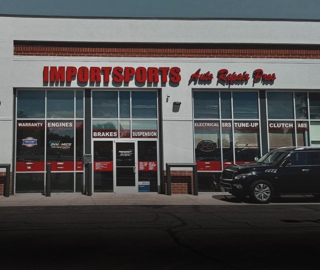 Yellow sports car and white station wagon parked in front of 