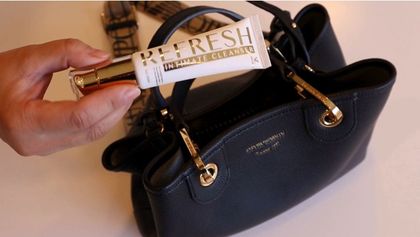 Two women are sitting at a table looking at a cell phone.