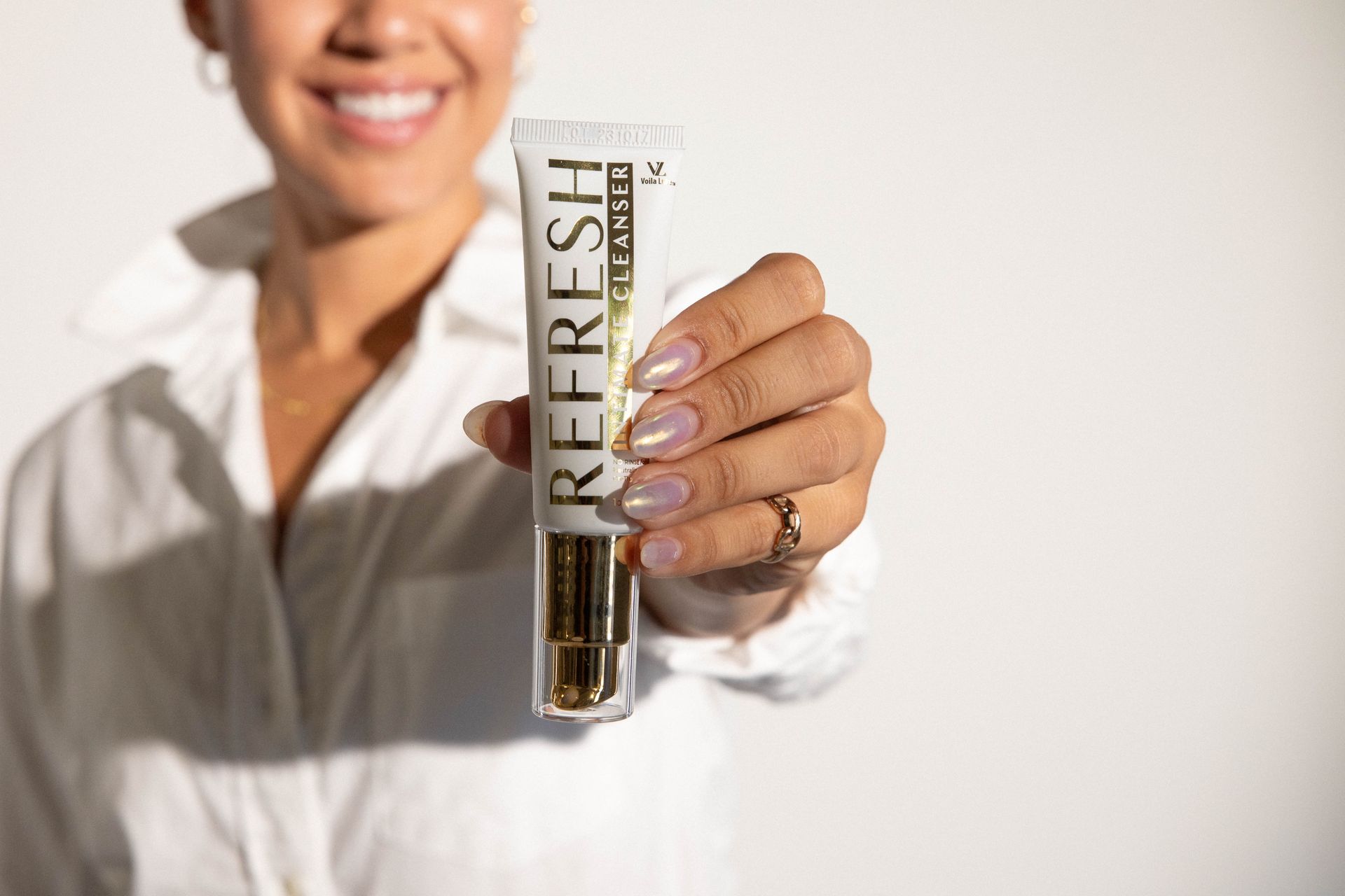 Woman smiling, holding a tube of