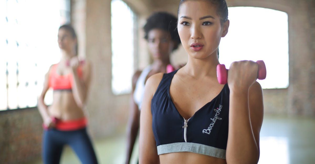 A group of women are lifting dumbbells in a gym.