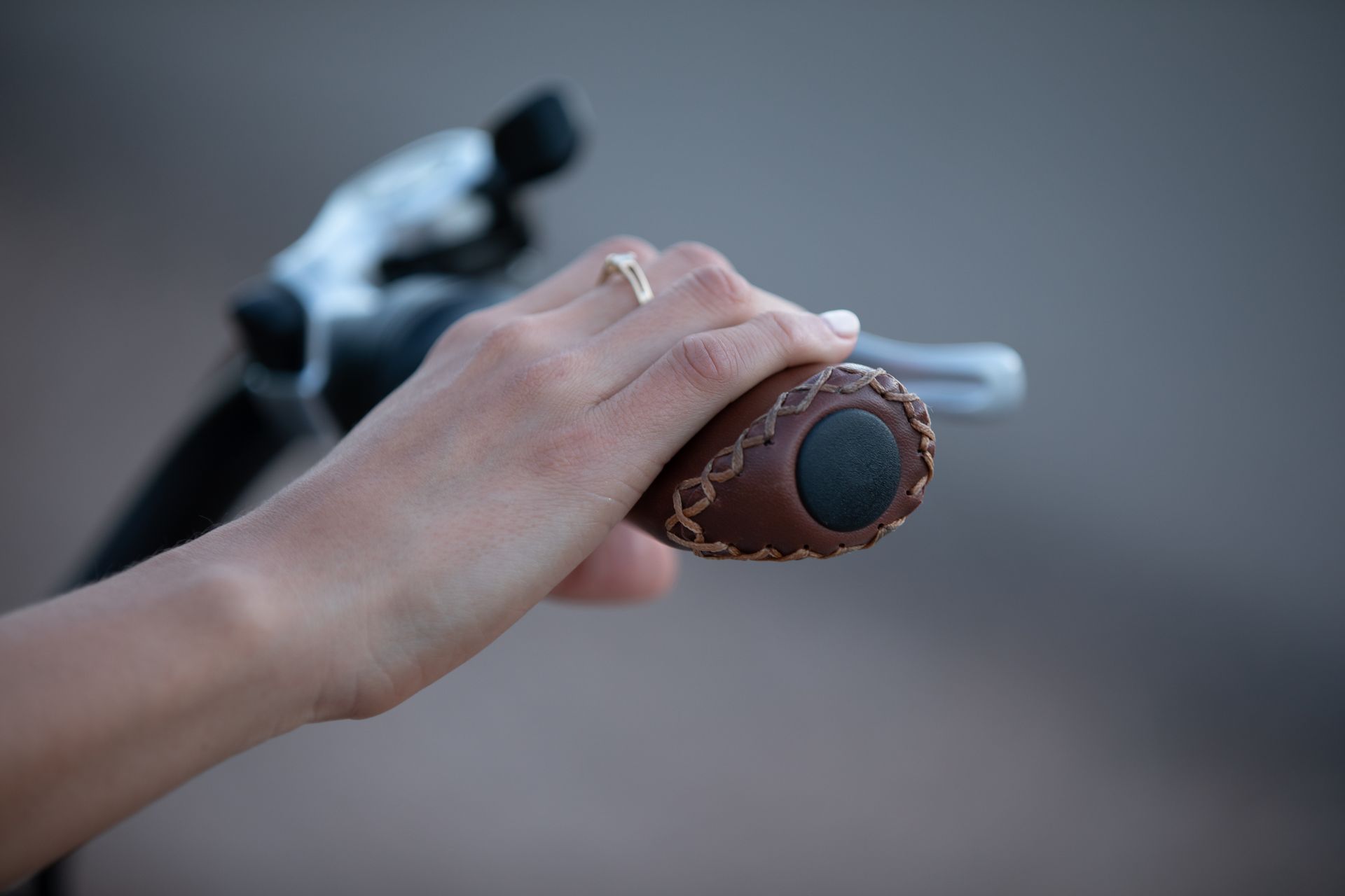 A woman is holding the handlebars of an electric bicycle.