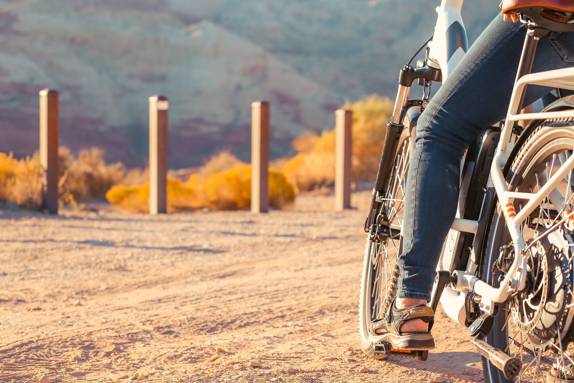 A person is riding an electric bike on a dirt road.