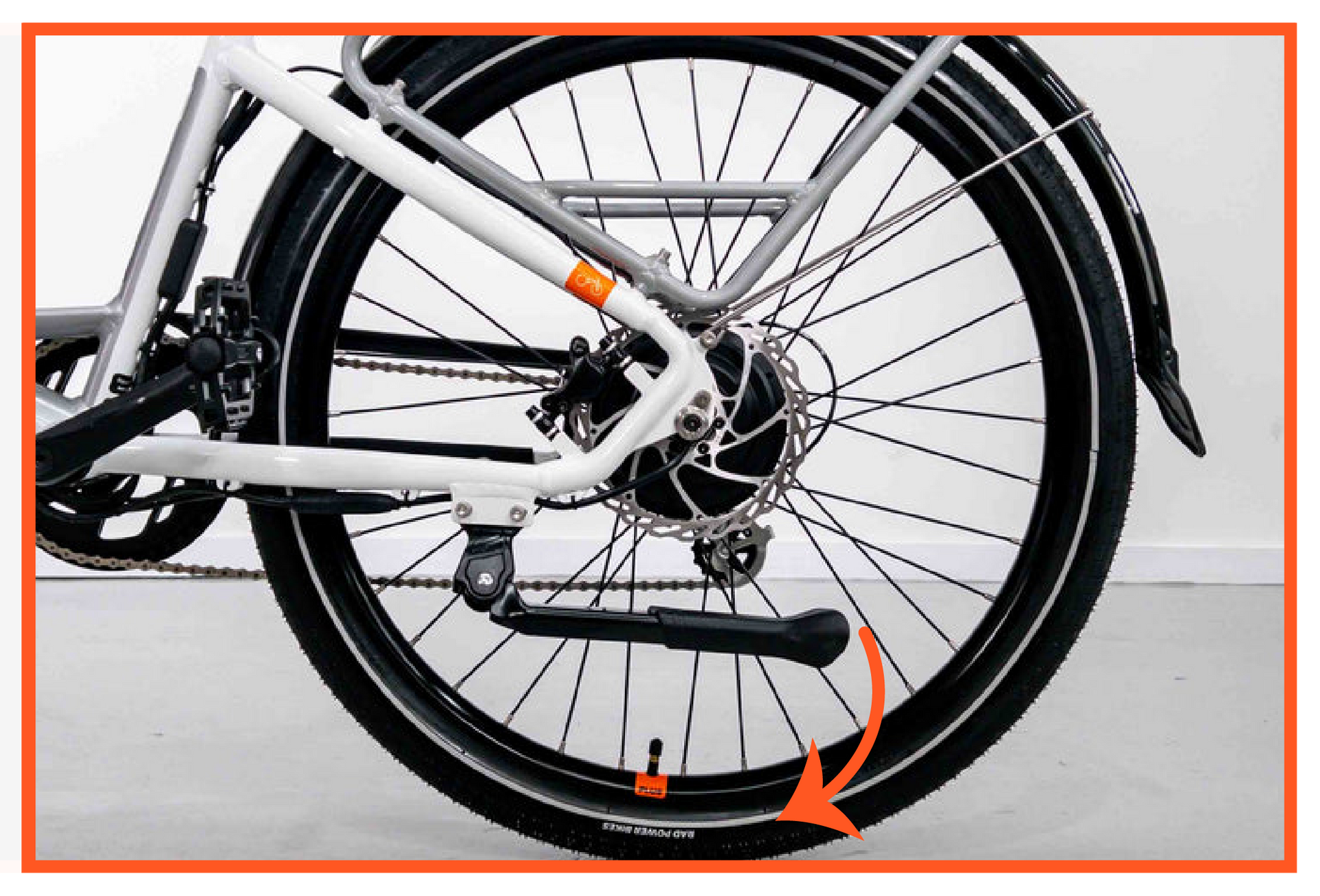 A close up of a bicycle wheel with a kickstand attached to it.