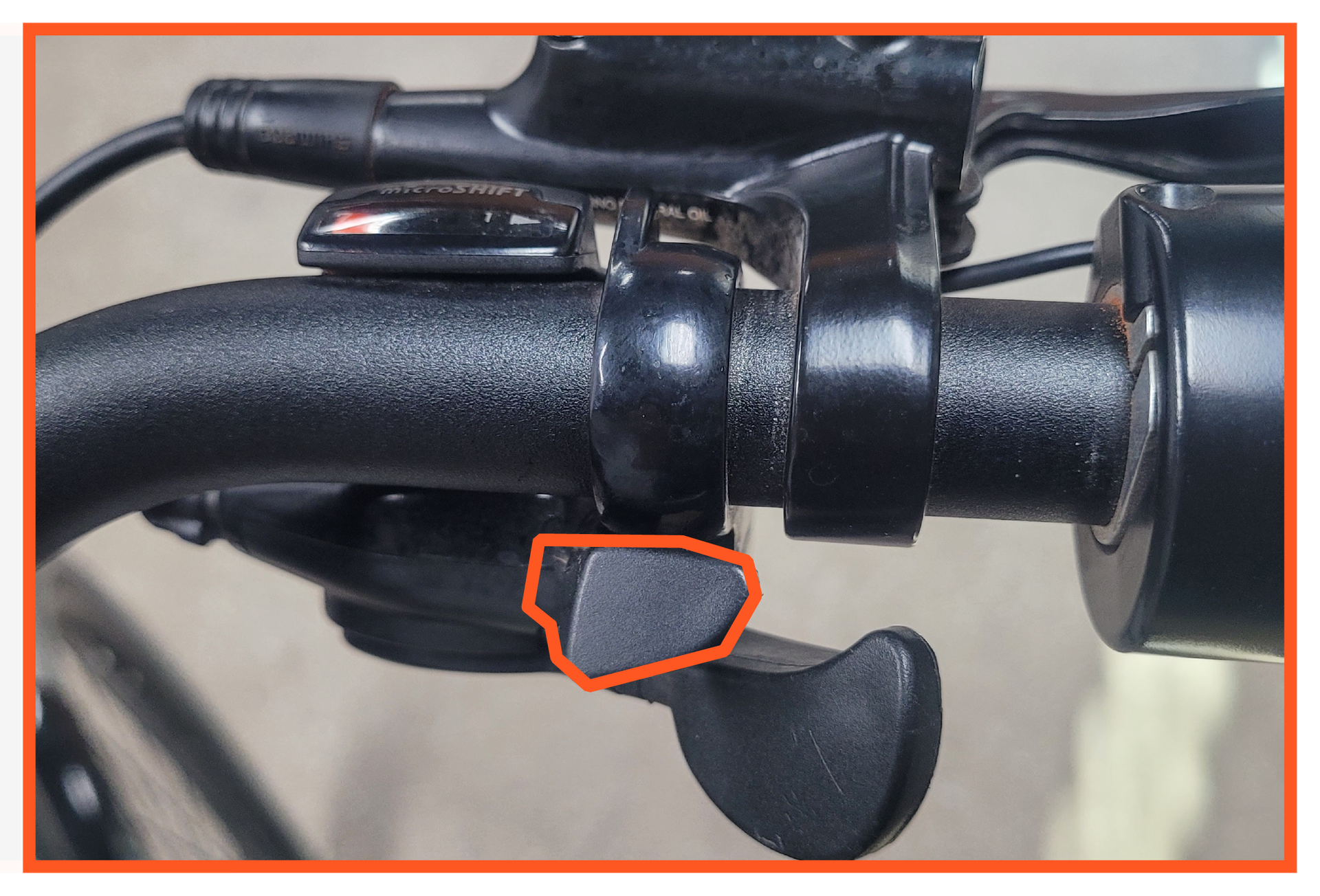 A close up of a bicycle shifter with a red circle around it.