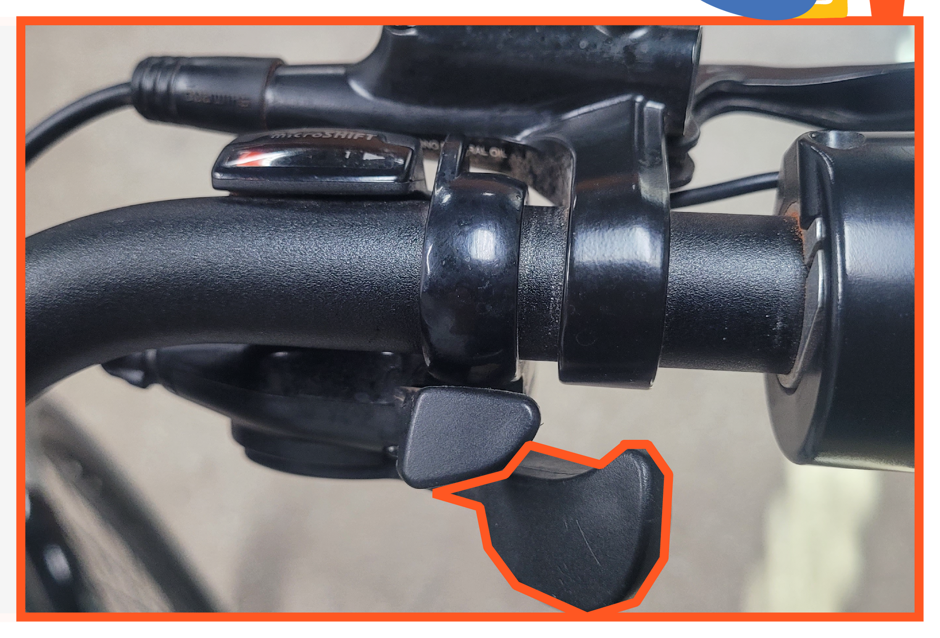 A close up of a bicycle handlebar with a shifter on it.