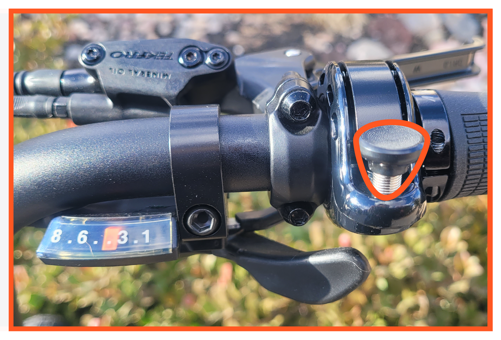 A close up of a bicycle shifter with a red circle around it.