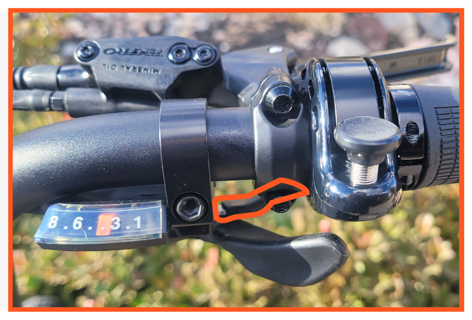 A close up of a bicycle shifter with a red arrow pointing to it.