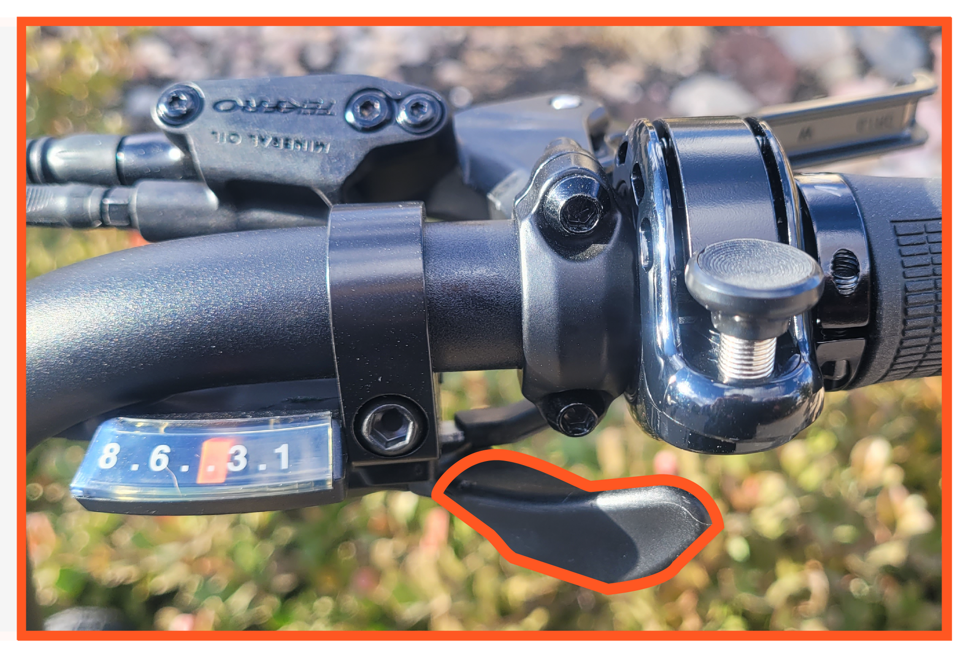 A close up of a bicycle shifter with a red circle around it.