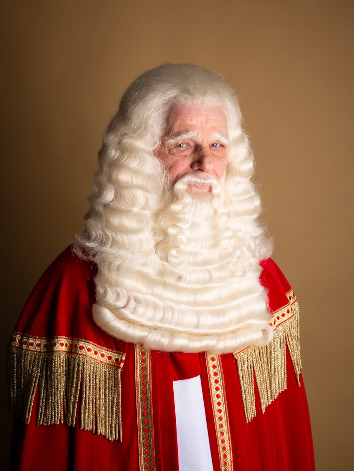 Man in rode gewaden met witte pruik en baard.