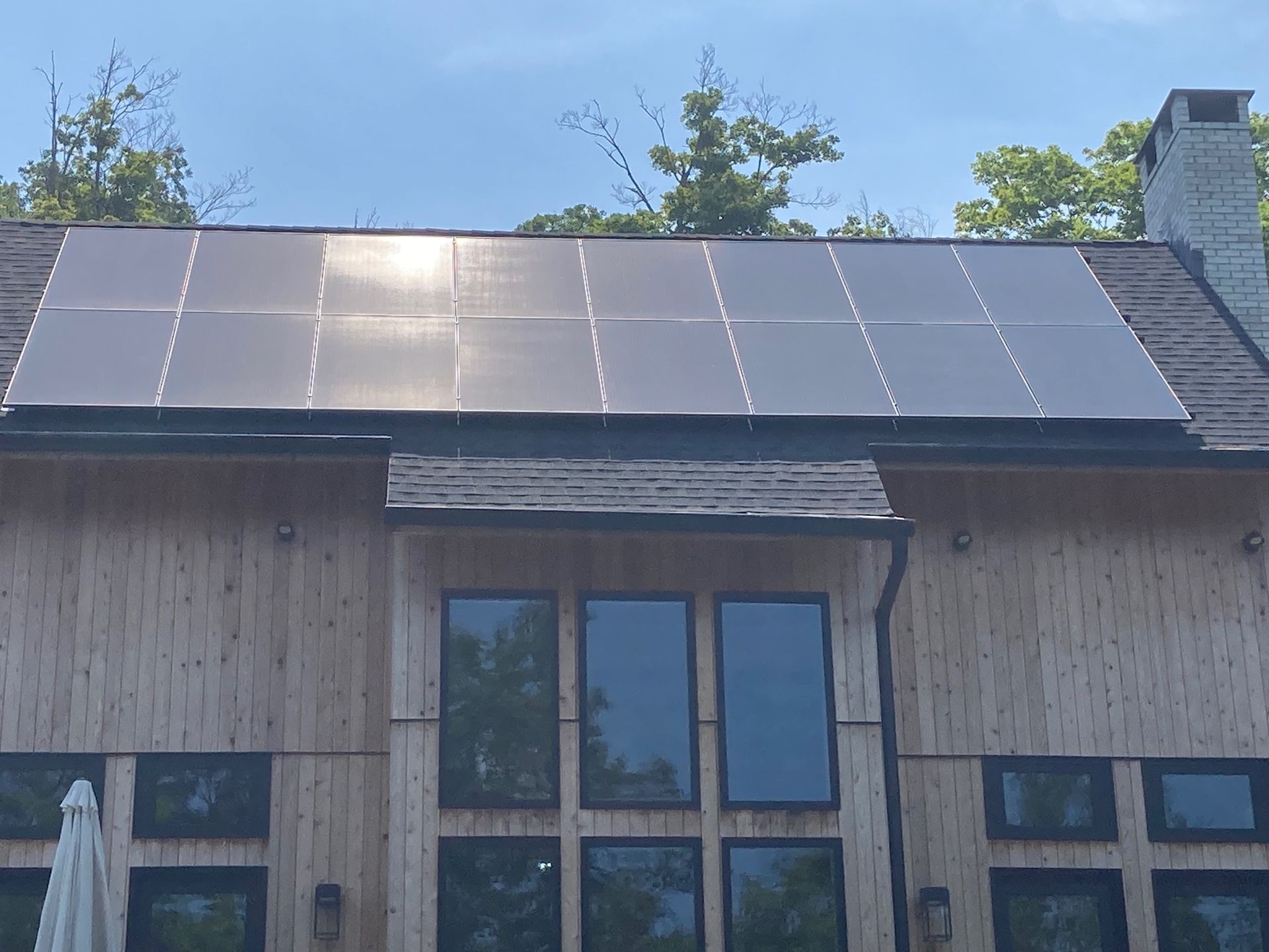 A house with a lot of windows and solar panels on the roof