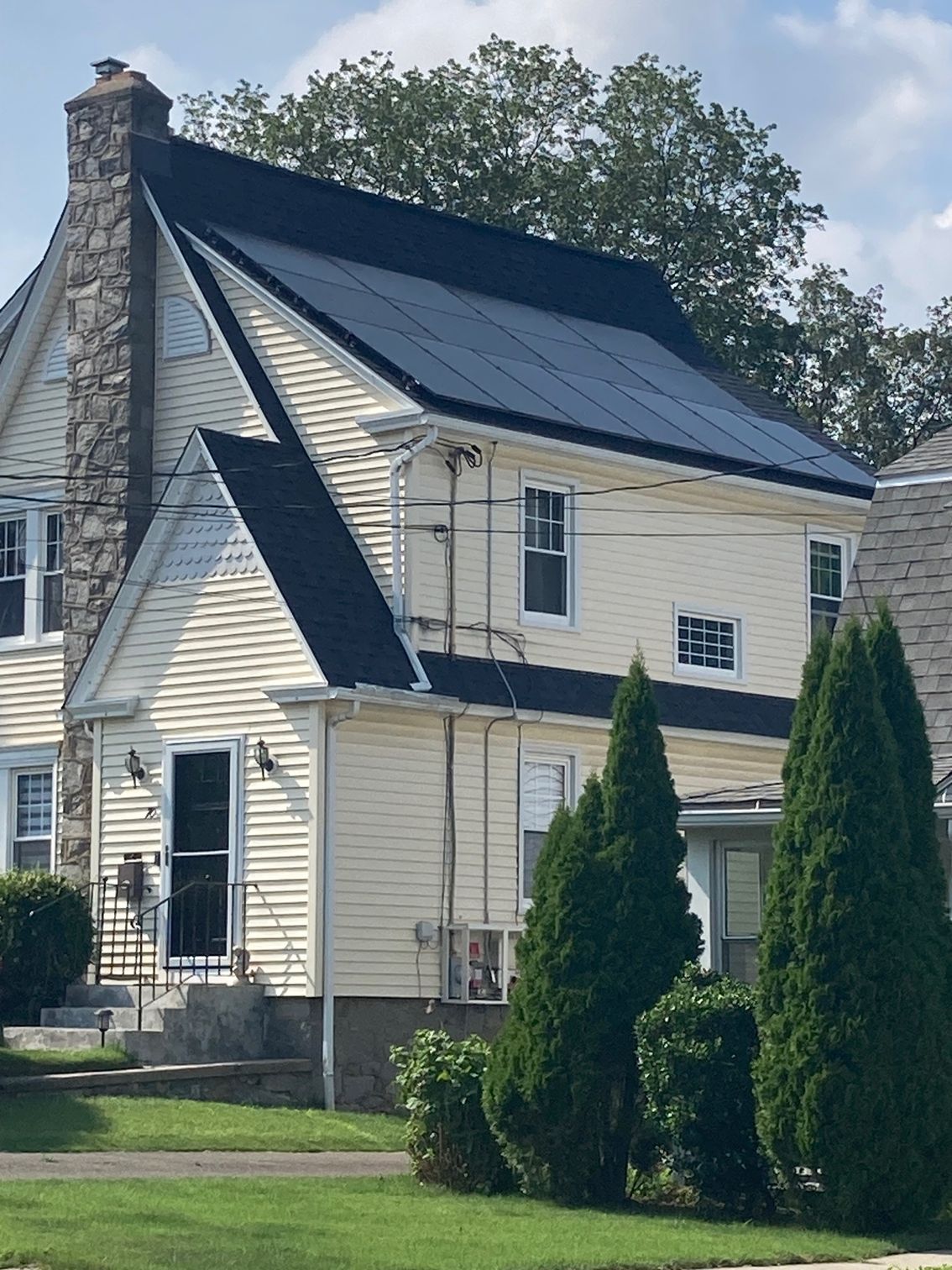 A white house with solar panels on the roof