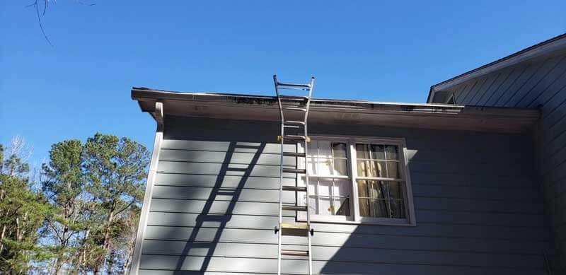 A ladder is sitting on the side of a house.