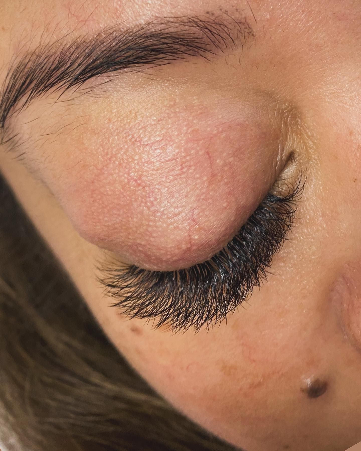 A close up of a woman 's eye with long eyelashes.