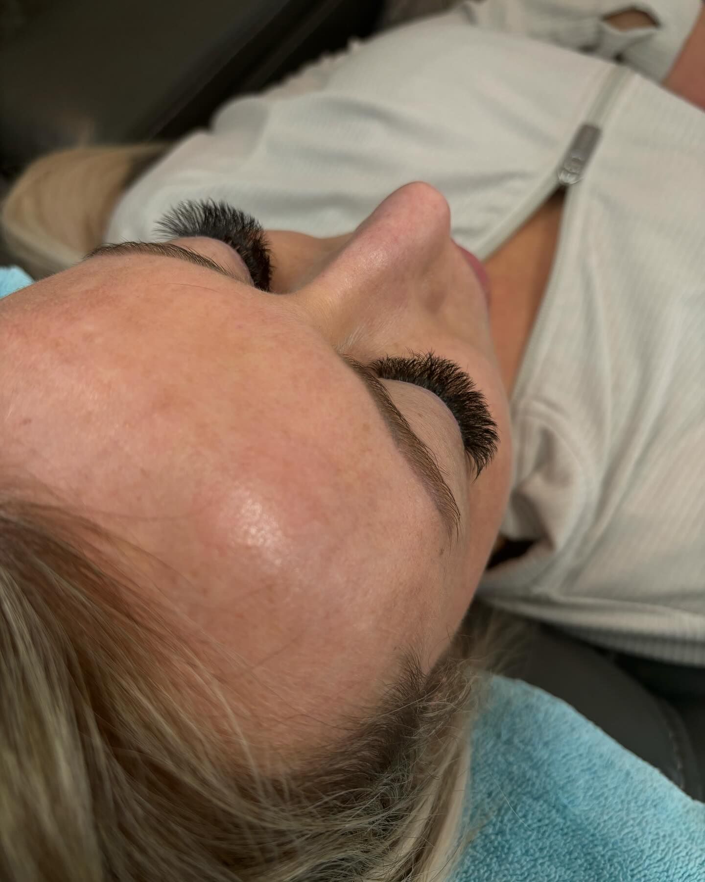 A close up of a woman 's face with long eyelashes.